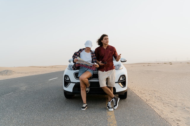 A couple on the road utilizing a physical map to check out their next destination.