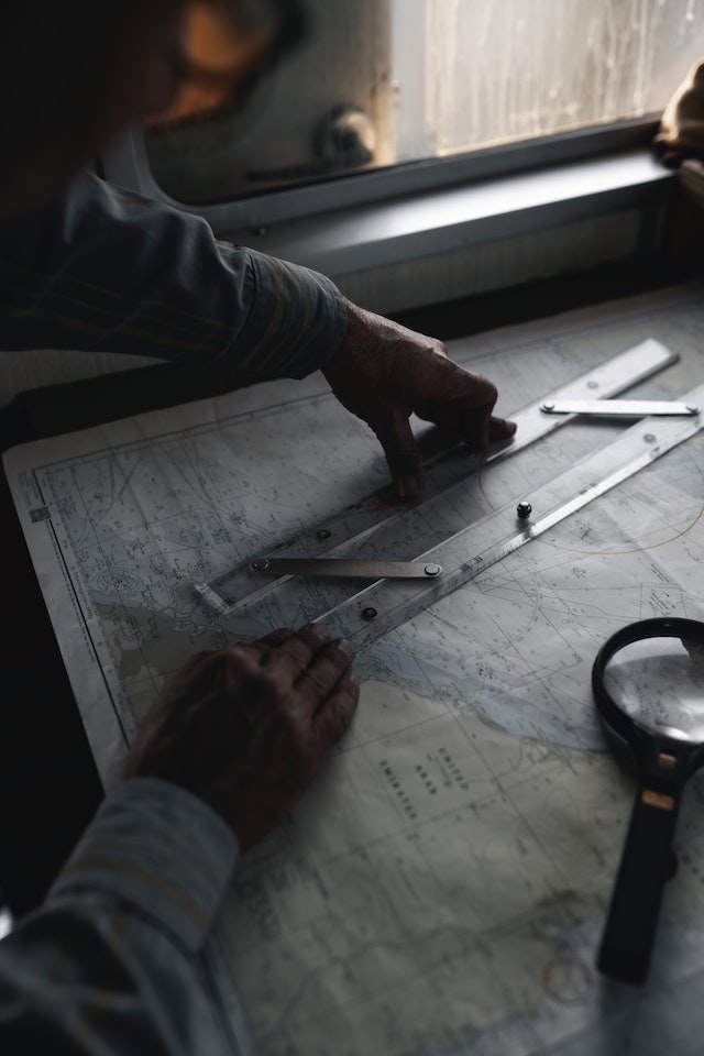 A man measuring the distance between two points on a map