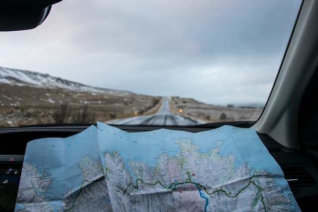 A physical map on a car’s dashboard for planning a long-distance road trip.