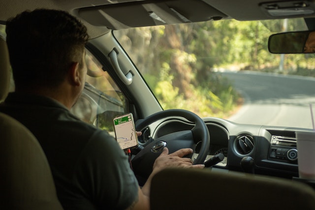 A driver is utilizing navigation features on Google Maps to find his way.