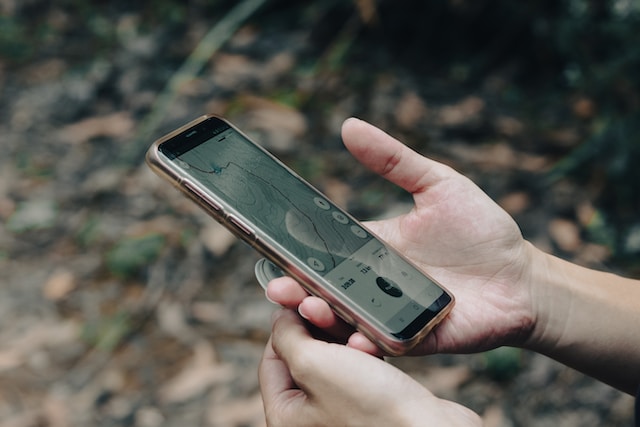 A young guy using his smartphone to navigate his surroundings via a navigation app on his phone.