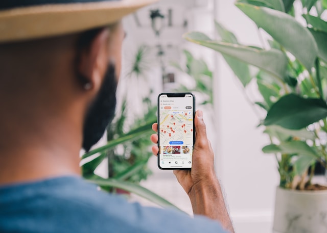 A user checking nearby points of interest from his location via a navigation app on his smartphone.
