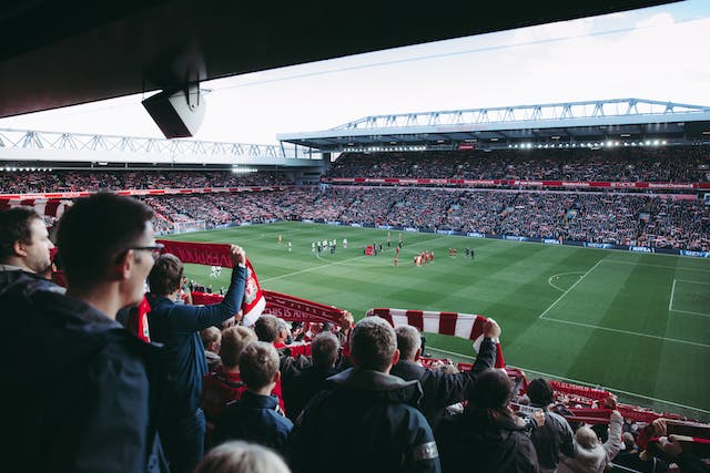 Thousands of supporters cheering their favorite team in a large stadium.