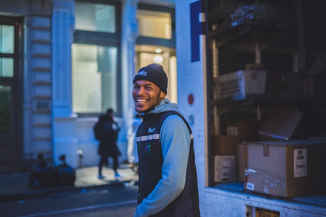 A delivery man happy after learning how to map delivery routes.