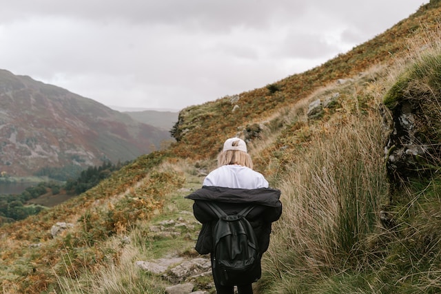 A lady taking an outdoor stroll along a trail during her leisure time.