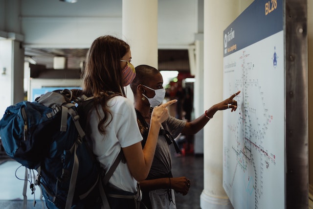 Two Tourists checking important landmark points on a city’s map.