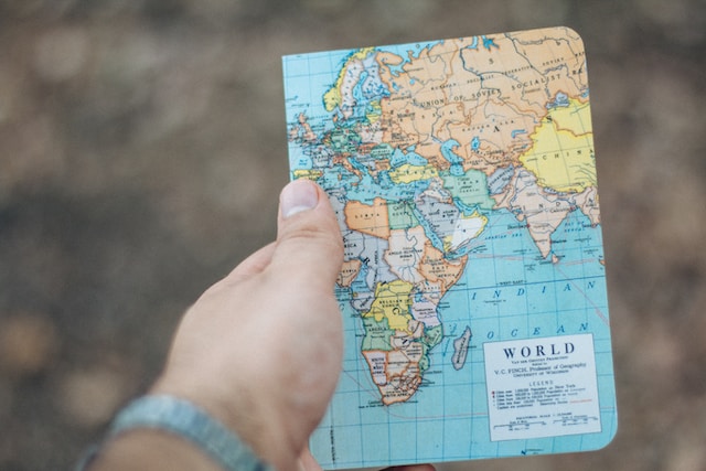A user holding a map containing a map legend at the bottom end.