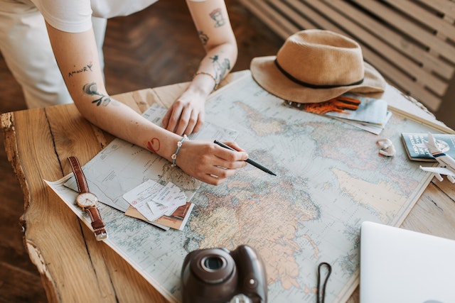 A woman checking out locations on a physical map using their geographic coordinates.