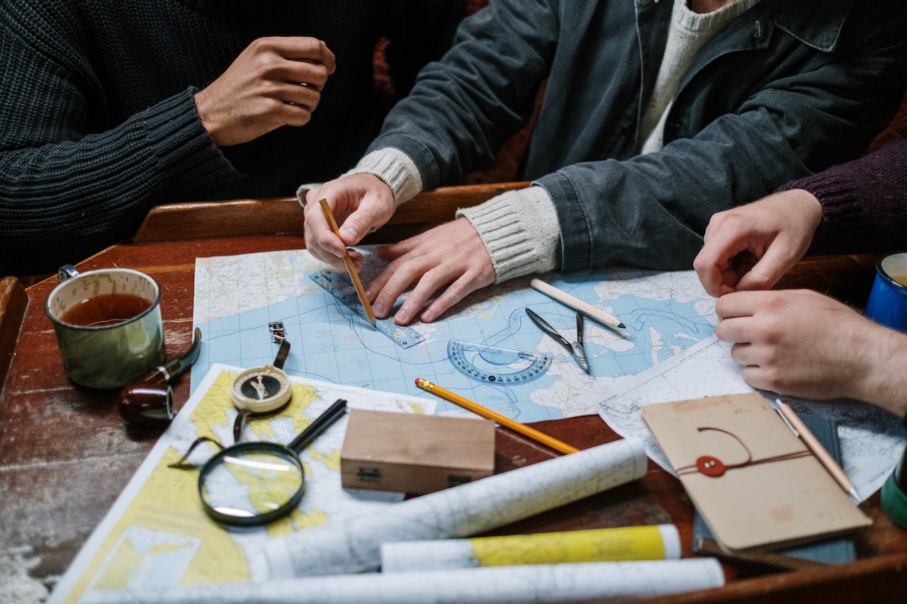A person drawing on a physical map with drawing tools