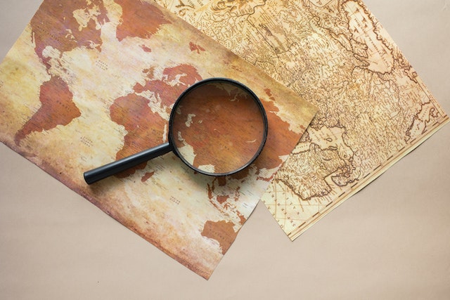 Two physical world maps and a lens.