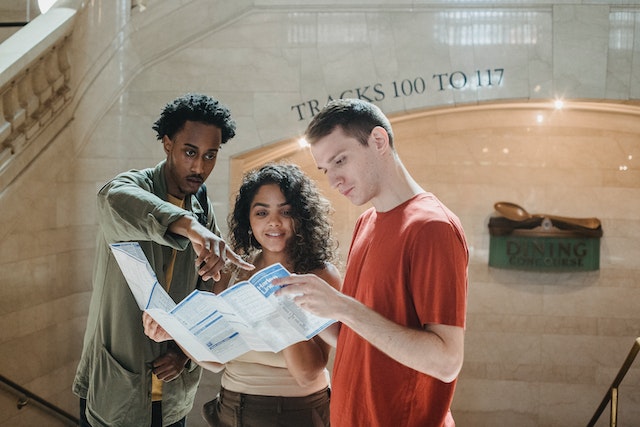 Three students actively use a map with symbols to understand their surroundings.