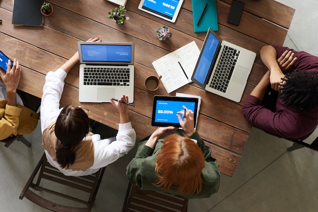 Top view of people discussing website experience in a team meeting.