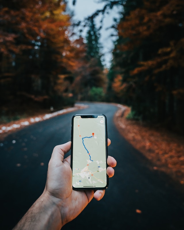 A man using his iPhone to seek the best route on Google Maps.