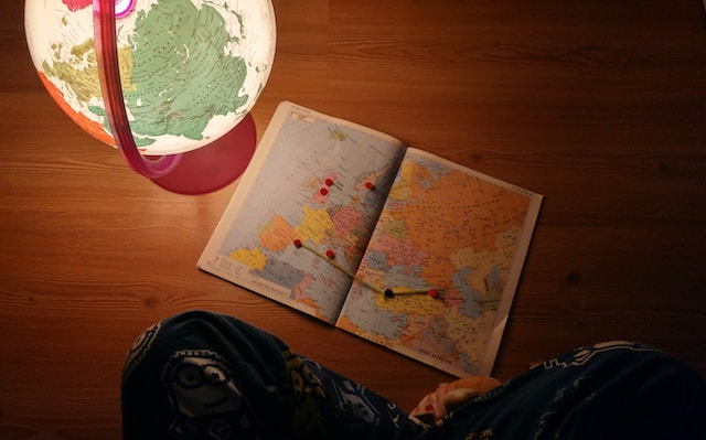 A map is displayed on a brown surface near a world map globe.